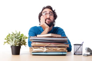 Man at desk thinking about choosing a document management system